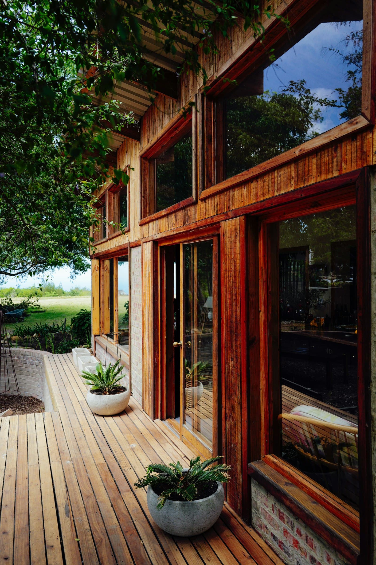 A modern home with large windows and an extended wooden deck — the architectural context where composite brand choice (Trex, TimberTech, Fiberon) is decided.