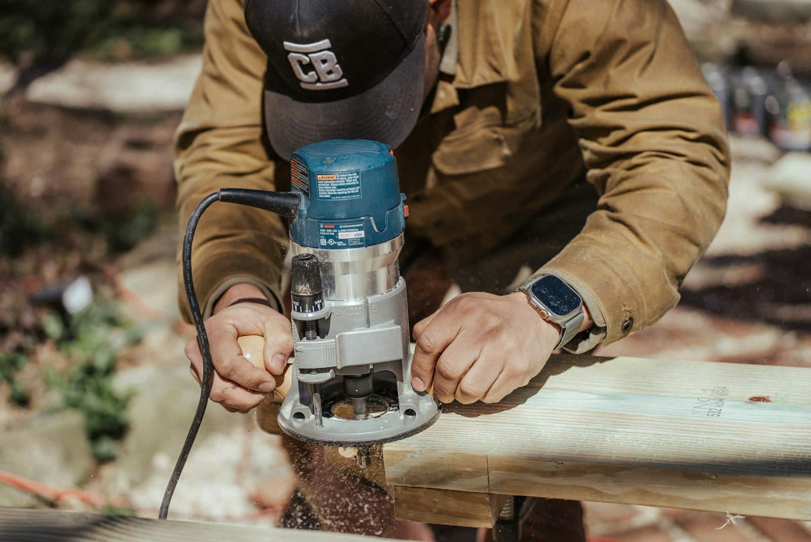 A contractor driving a screw into a deck board with a power drill — the per-square-foot labour work behind every GTA quote.