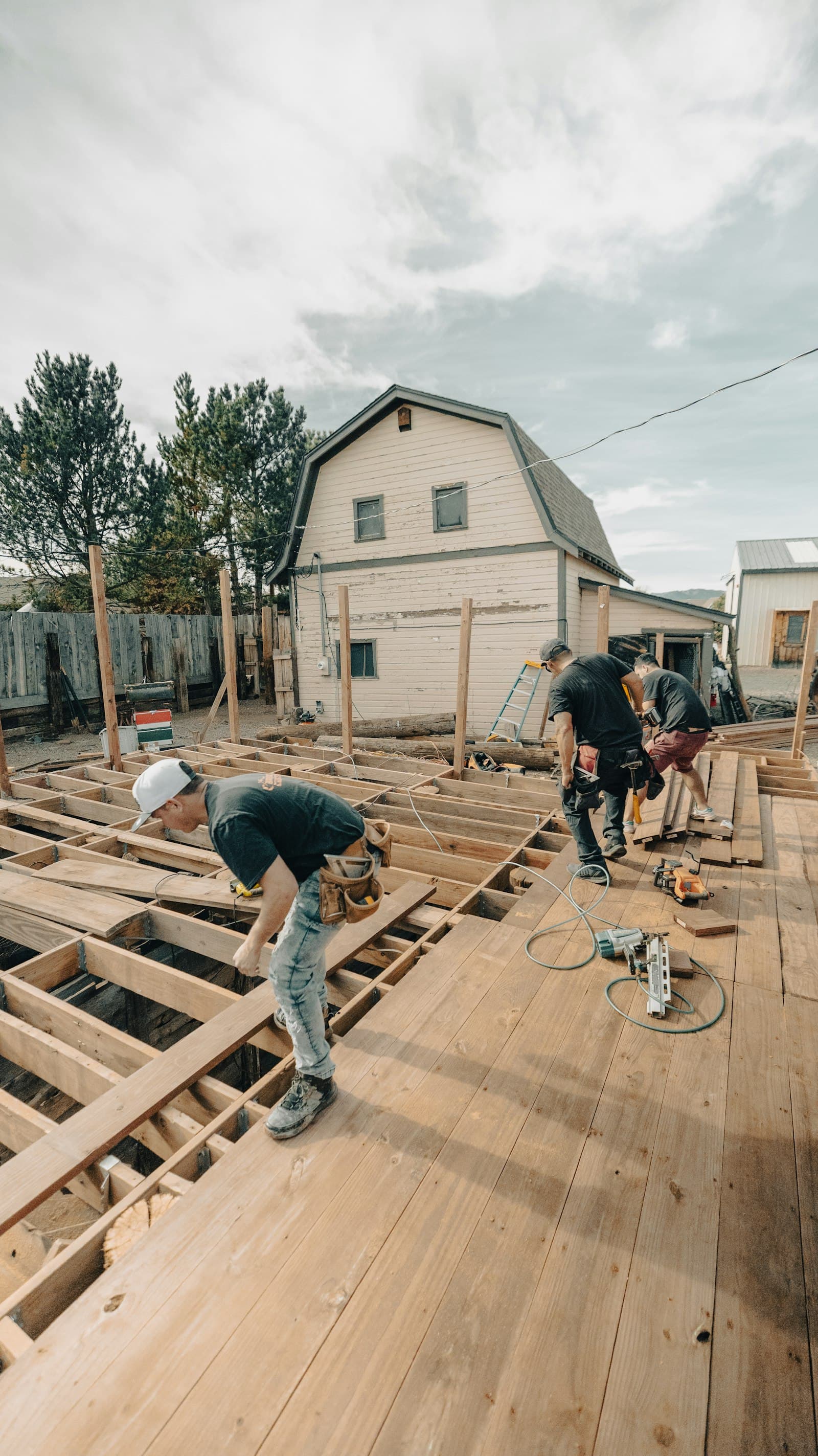 Construction workers framing a residential deck outdoors — the structural work Toronto Building inspectors are signing off on at every permit milestone.