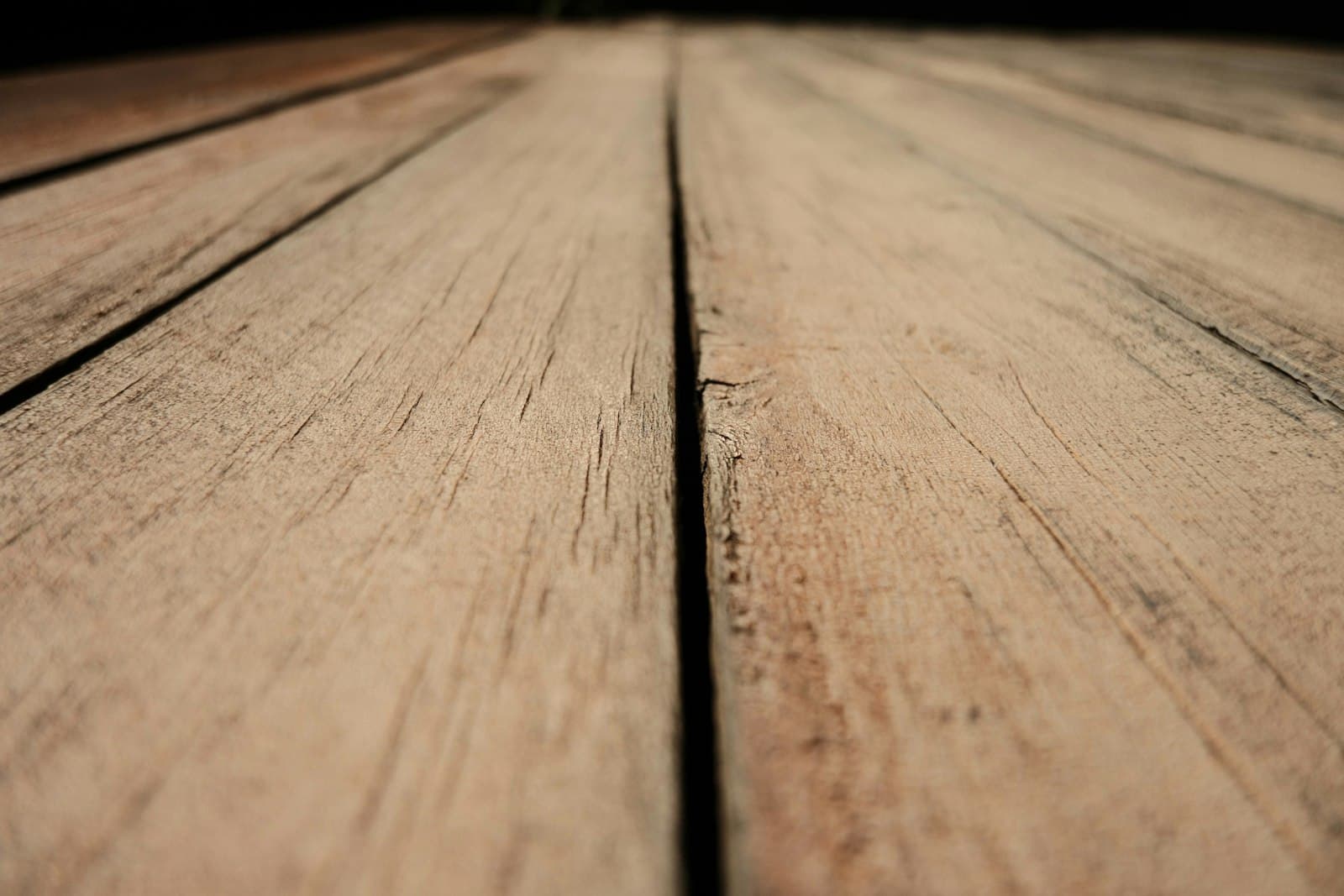 Close-up of weathered cedar deck planks showing the silvery surface fibers and grain lift that produce splinters on Toronto cedar decks.